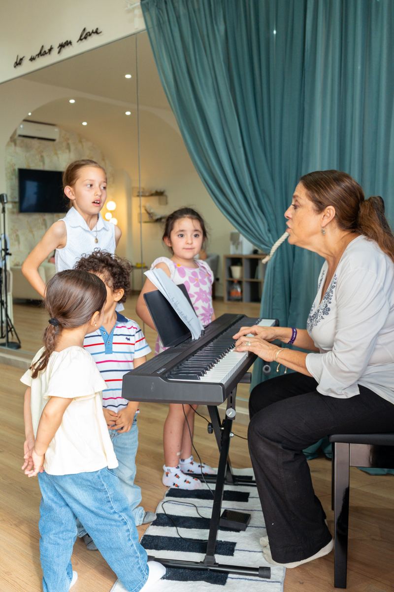 Maestra al piano con un grupo de niños