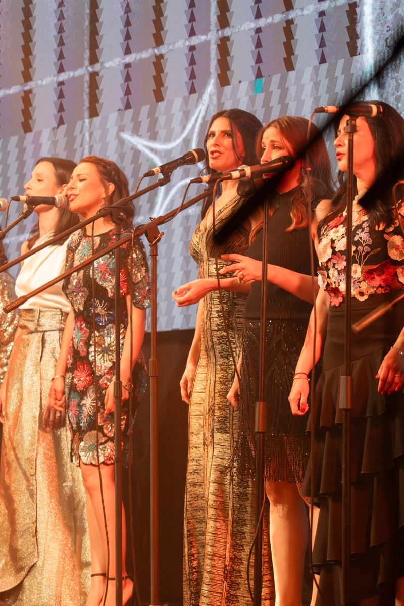 Alumnas cantando con micrófono en el concierto anual