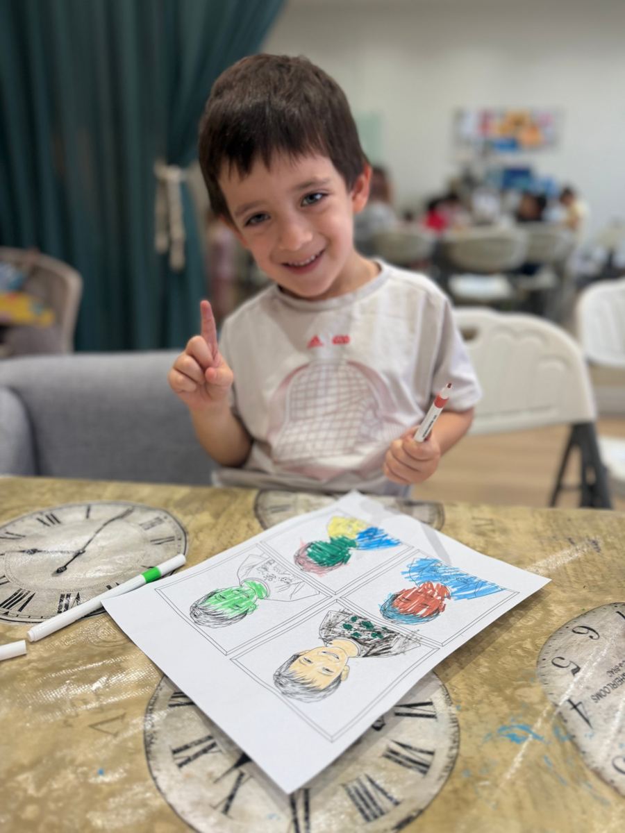 Niño sonriendo con su dibujo terminado